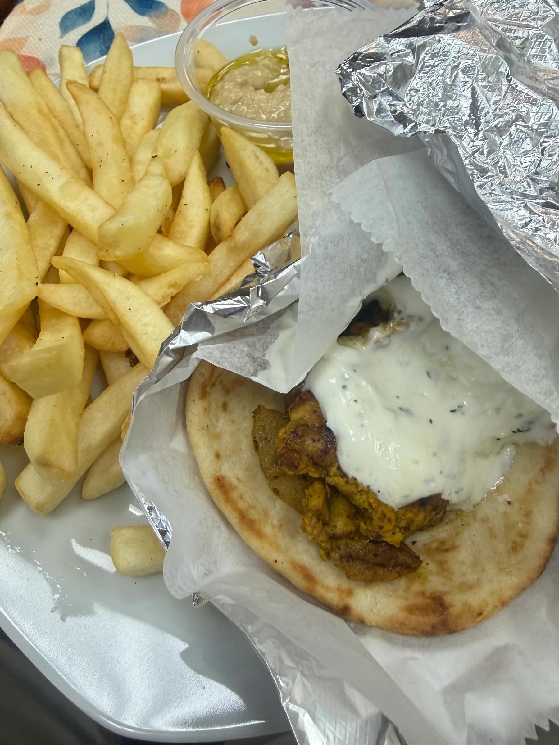 Grilled chicken shawarma with grilled onion and peppers and yogurt mint sauce — comes with fries and hummus.